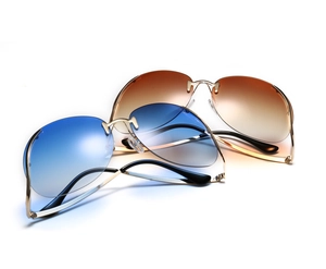 Détail de lunettes de soleil sans monture avec verres dégradés et fines branches dorées