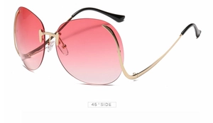 Détail de lunettes de soleil papillon dégradé rose avec monture dorée sous un angle de 45°