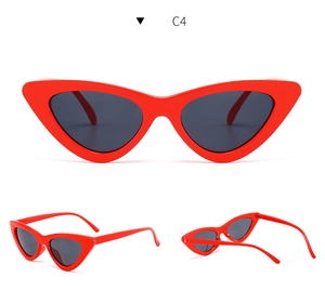 Detailed close-up of red cat-eye sunglasses with dark grey polarized lenses and metal hinges