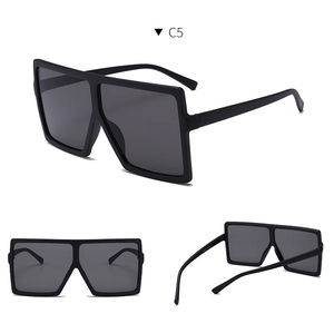 Close-up of black oversized square sunglasses with smoke lenses and sleek frame detail