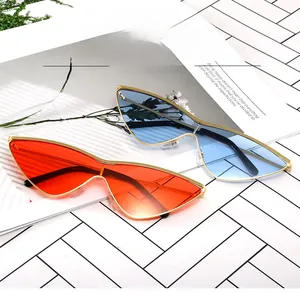 Detail of triangle cat-eye sunglasses with thin gold metal frames on a fashion magazine
