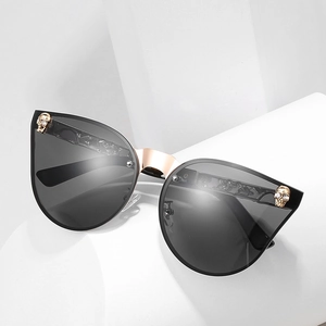 Lunettes de soleil cat-eye gothiques avec crânes dorés et accents en cristal brillant