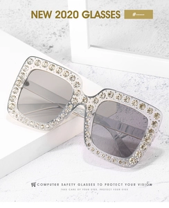 Detailaufnahme des eckigen Sonnenbrillenrahmens mit luxuriösem Strass-Besatz am Rand