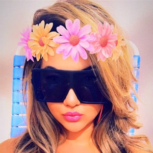 Fashionable oversized square black sunglasses worn by a female model in a sunny setting