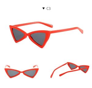 Detail view of butterfly cat-eye sunglasses in vibrant red with dark gray lenses