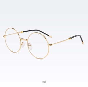 Vue de côté des lunettes rondes rétro en métal doré avec embouts de branche noirs
