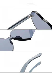 Détail de lunettes de soleil en forme de cœur avec monture grise et charnières en métal