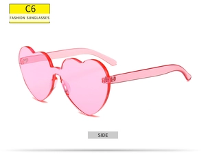 Vue latérale de lunettes de soleil sans monture en forme de cœur rose transparent