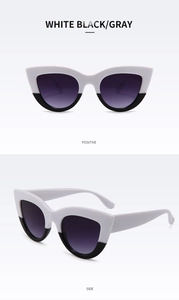Detail view of cat eye sunglasses with white and black frame and gradient lenses