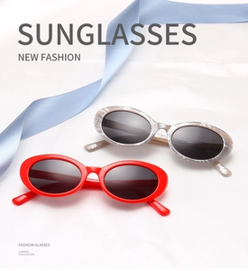 Oval alien sunglasses in red glossy finish and grey marble texture on white silk fabric