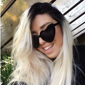 Occhiali da sole alla moda neri a forma di cuore con montatura spessa indossati da modella
