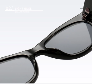 Macro detail of high-gloss black sunglasses frame showing light nose bridge quality