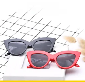 Top view of fashionable black and red cat eye sunglasses on a decorative grid background