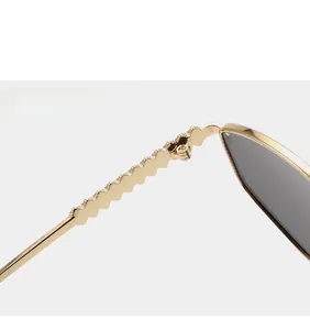 Detail of durable metal hinges and wavy temple design on vintage gold sunglasses