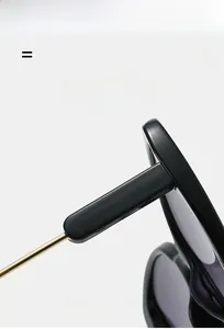 Detailed macro view of the gold hinge connecting the black frame and sleek metal temple