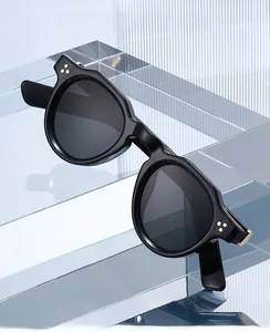 Detailed macro view of vintage round black frames with silver triple-dot rivet accents