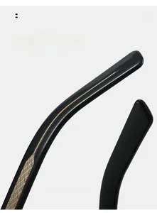 Detail of curved black acetate sunglasses temple with embossed golden metal core