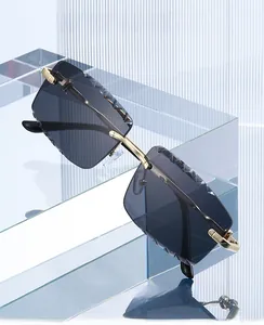 Close-up of diamond-cut edges on rimless rectangular metal sunglasses with gold temples