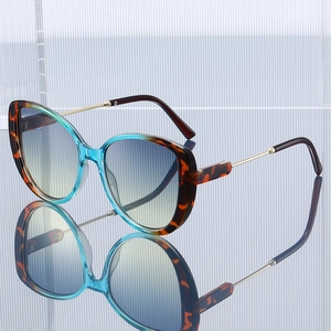 Chic butterfly frame sunglasses with tortoiseshell and blue trim on mirrored surface