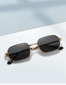 Detail of gold metal frame sunglasses with dark polygonal lenses and sleek temples