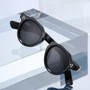 Vintage round thick frame sunglasses in black with gold rivet accents for men and women