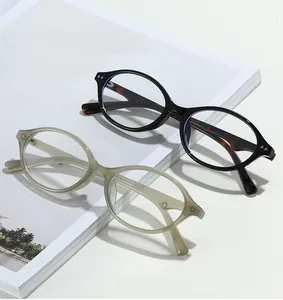 Flat lay of oval tortoiseshell and translucent olive glasses on a white magazine