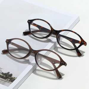 Retro tortoiseshell and amber oval blue light blocking glasses on an art book