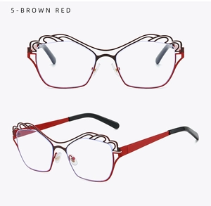 Detail view of red-brown irregular metal frame glasses with hollowed wave pattern on top