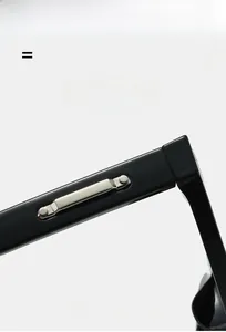 Detail of glossy black cat-eye sunglasses frame with durable metal hinge and texture material