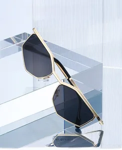 Detailed view of polygon cat eye sunglasses with gold metal frame on a glass stand