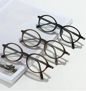 Detailed close-up of retro round frame glasses stacked on a magazine showing fine textures