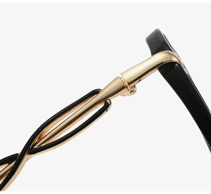 Detail of butterfly glasses frame featuring twisted gold metal temple and black acetate