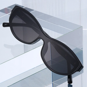 Stylish black cat-eye sunglasses with dark lenses on modern minimalist glass display