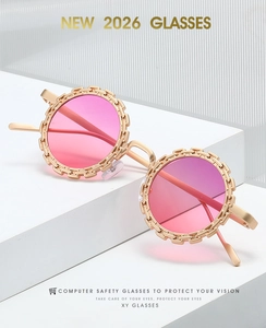 Détail de lunettes de soleil fleurs avec monture dorée et verres dégradés roses