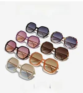 Détail de lunettes de soleil hexagonales avec verres dégradés et charnières en métal doré