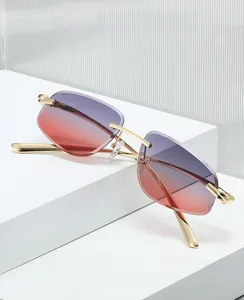 Close-up of rimless gradient sunglasses with gold metal temples on a display stand
