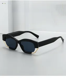 Detail of polygonal black sunglasses with elegant gold metal trim and polarized lenses