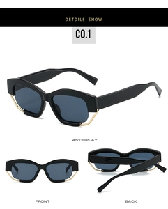 Detail of black geometric sunglasses with gold wire accent on frame lower edge
