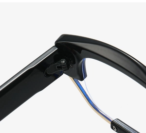 Close-up of black oversized frame hinges with gold metal accents and precision screws
