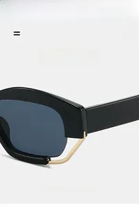 Detail view of bold black polygonal sunglasses with sleek golden metal trim accents