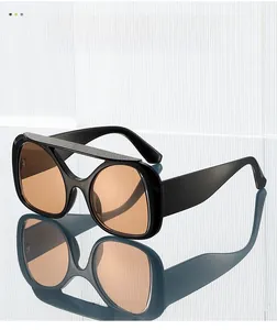 Macro view of oversized Y2K sunglasses with black frames and tinted lenses on mirror surface