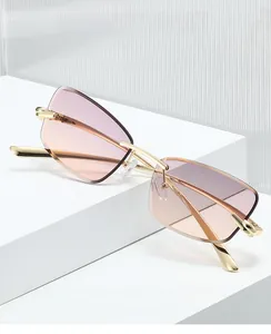Détail de lunettes œil-de-chat sans monture, verres dégradés roses et cadre en métal doré