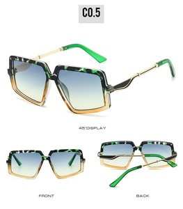 Detail view of large square sunglasses featuring green tortoiseshell frames and gradient lenses