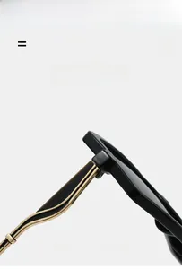 Detail of sunglasses featuring black acetate frames and golden metal temple hinges