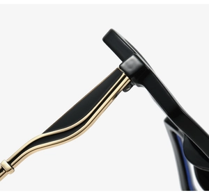 Détail des branches de lunettes noires avec élégantes décorations métalliques dorées