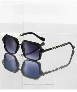 Détail de lunettes de soleil carrées avec verres dégradés violets et détails dorés aux branches