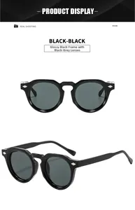 Detail view of vintage round black sunglasses with silver rivet accents and dark lenses