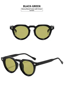Detail of vintage round sunglasses in black with yellow-green lenses and silver rivets