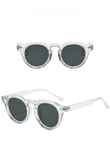 Detail of transparent acetate round frame sunglasses with metal rivet and grey lenses