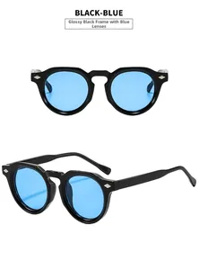 Detail of retro round sunglasses in bright black frame with blue lenses and metal rivets